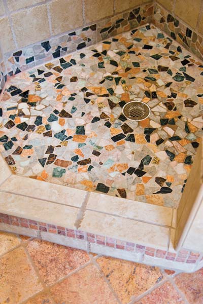 The shower floor is finished with natural, honed river rock from DuraTile, with a sustainable, chemical-free webbing and good slip resistance.